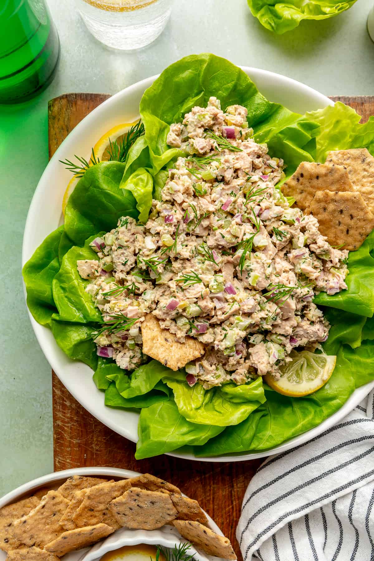 Classic Tuna Salad on bed of lettuce with crackers ticking in it.