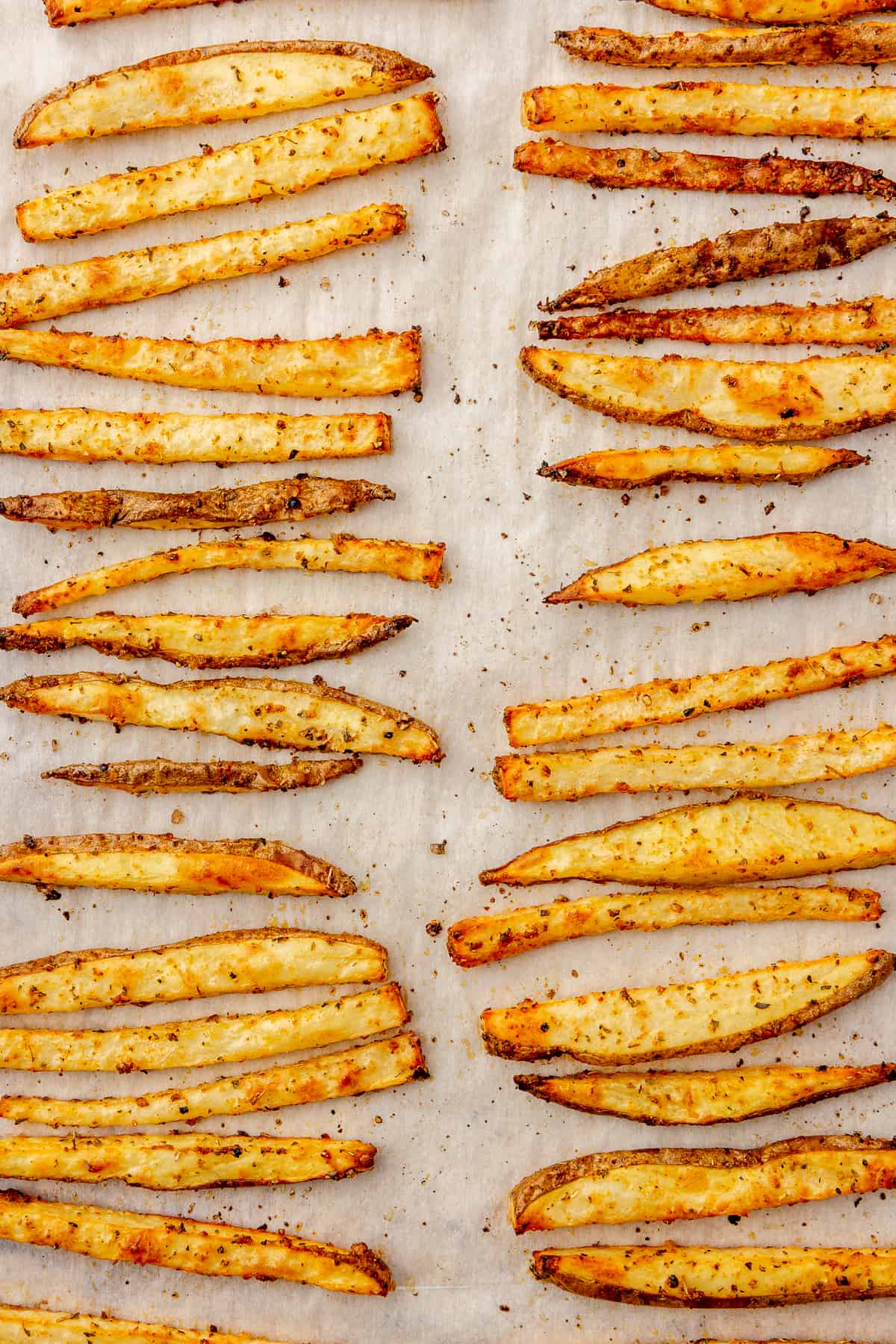 Seasoned baked fries on a sheet pan.