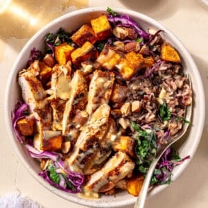 Blackened Chicken and Sweet Potato Bowls in a white bowl with fork in it.