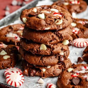 Double Chocolate Peppermint Cookies stacked on top of each other on a sheet pan.