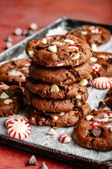 Double Chocolate Peppermint Cookies stacked on top of each other on a sheet pan.