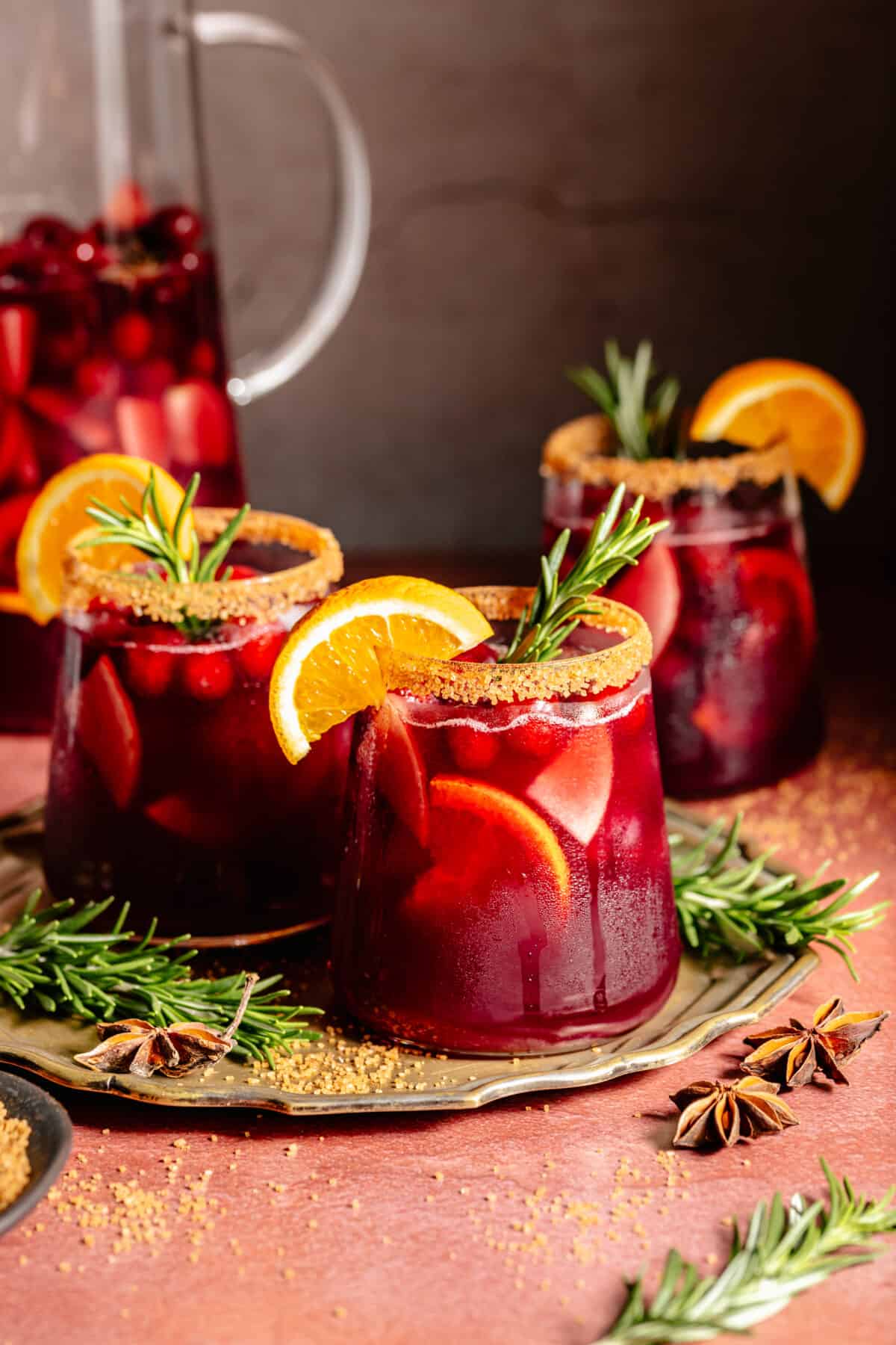 Holiday Sangria in a pitcher plus served in three stemless glasses.