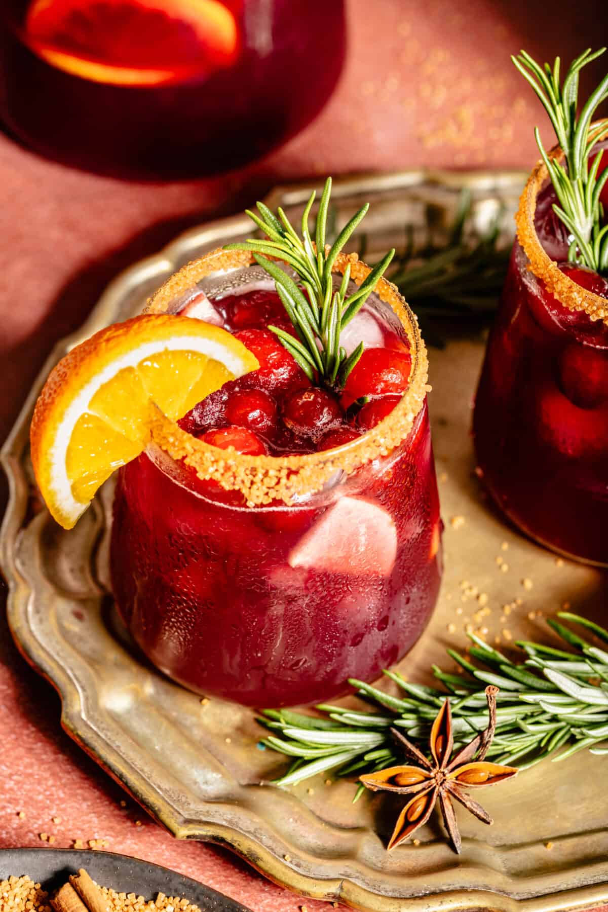 Glass of Holiday Sangria. Orang slice on rim. Spring of rosemary in glass.
