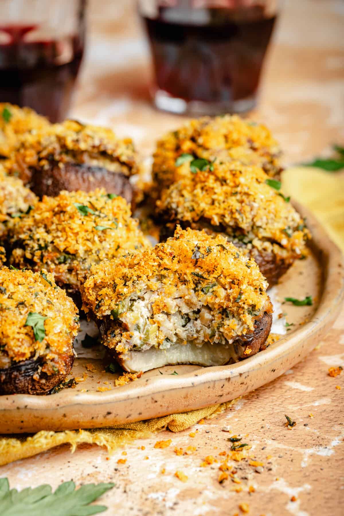 Sausage Stuffed Mushrooms on a plate. Bite taken out of one mushroom.