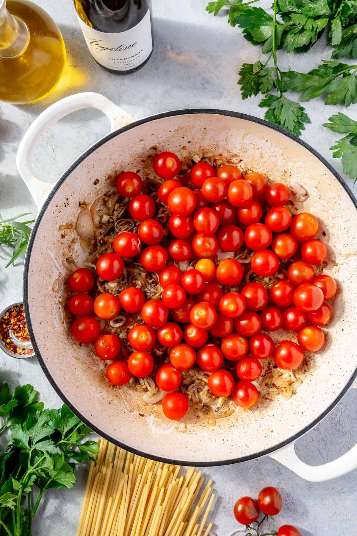 Whole cherry tomatoes in skillet with anchovy mixture.