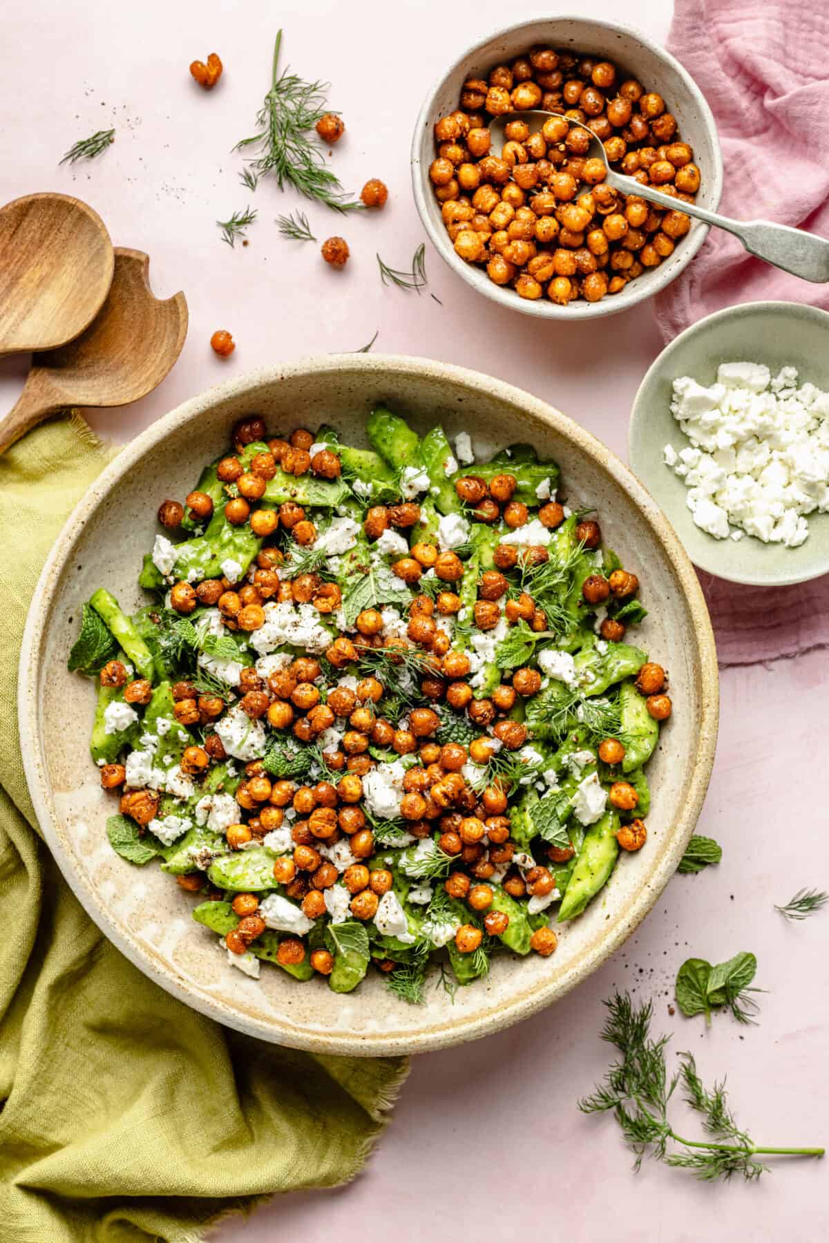 Salad in large bowl with feta and chickpeas scattered around.