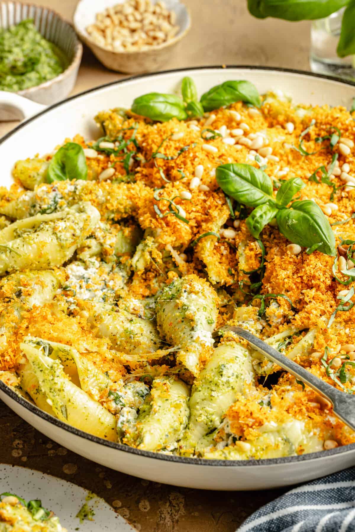 close up of pesto unstuffed shells in skillet.