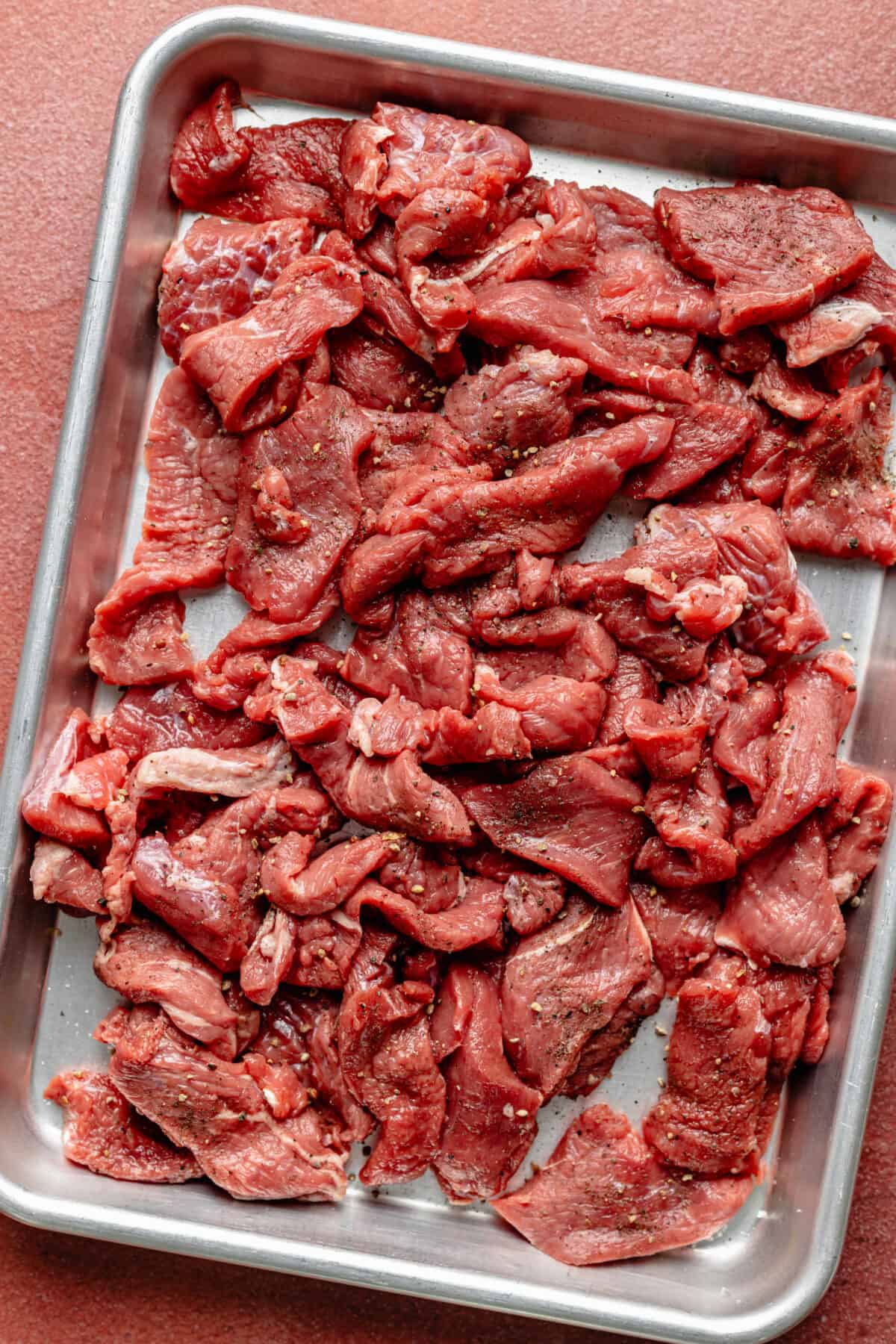 Sliced steak on sheet pan. 