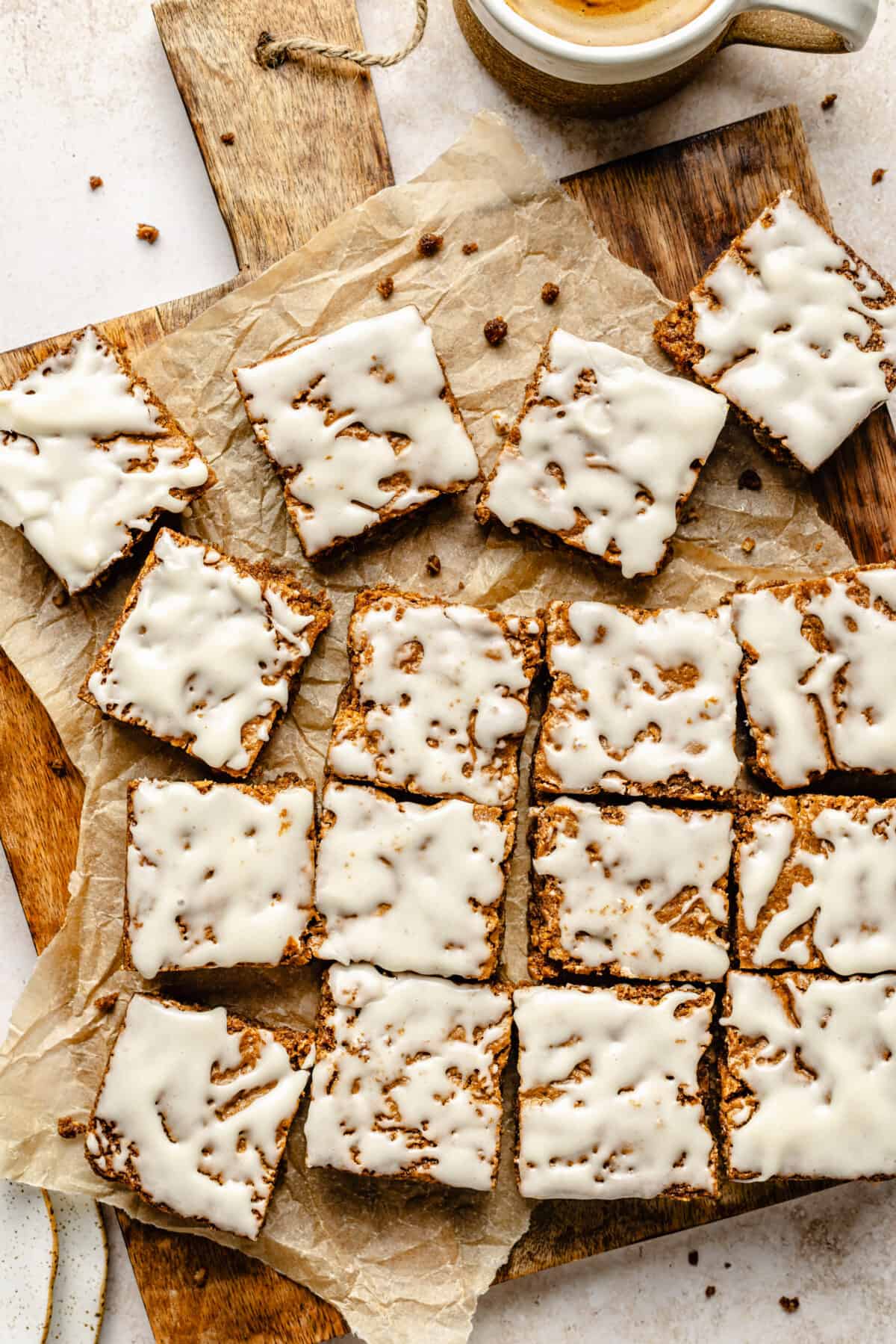 Iced Oatmeal Cookie Bars sliced on wooden board.