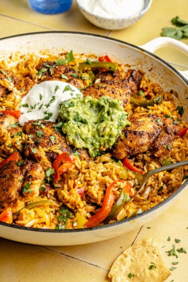 Chicken and Rice Taco Skillet with sour cream and guacamole on top.