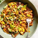 Gochujang and Peanut Veggie Noodles in green bowl with fork.