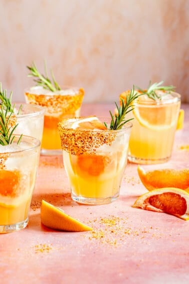 Skinny Rosemary Paloma in glasses with garnishes scattered.