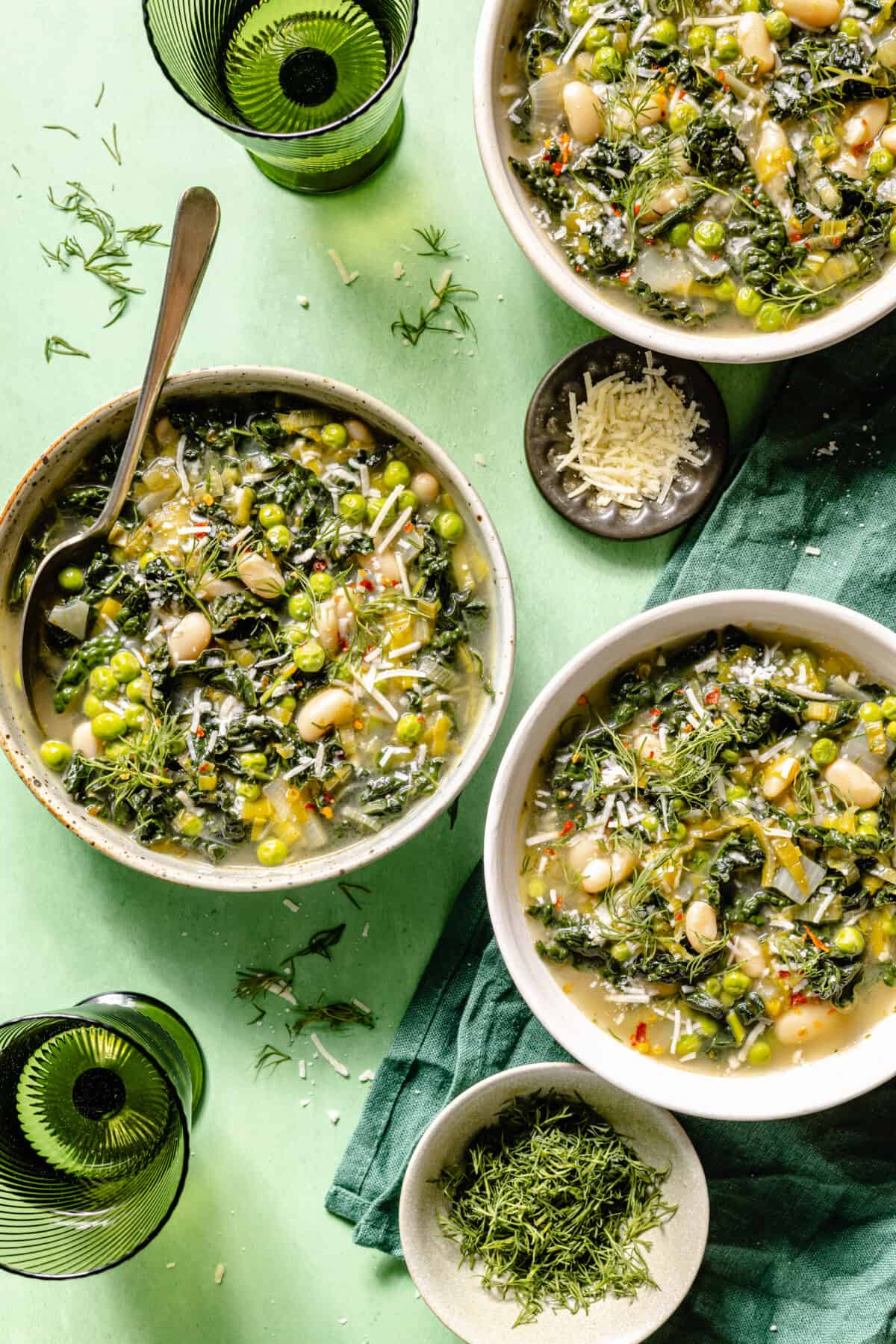 Spring Green Minestrone in three bowls on green backdrop.
