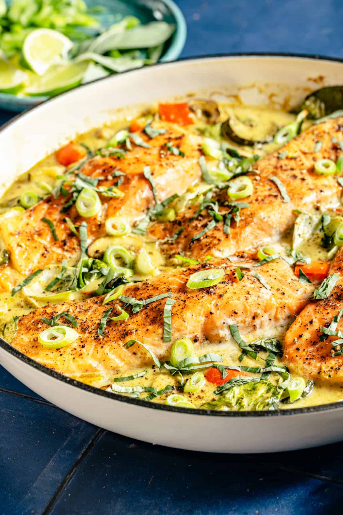 Close up of Thai-Inspired Coconut Green Curry Salmon in white skillet.