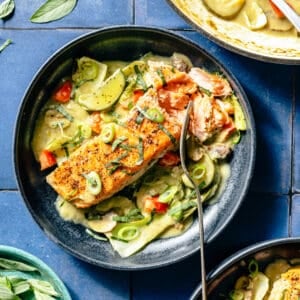 Thai-Inspired Coconut Green Curry Salmon plated in blue bowl.