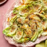 a pink platter with creamy little gem lettuce salad and toasted breadcrumbs