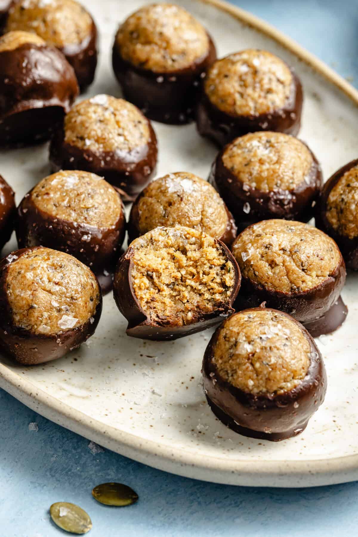 protein balls dipped in melted chocolate and garnished with flaky salt