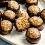 protein balls dipped in melted chocolate and garnished with flaky salt