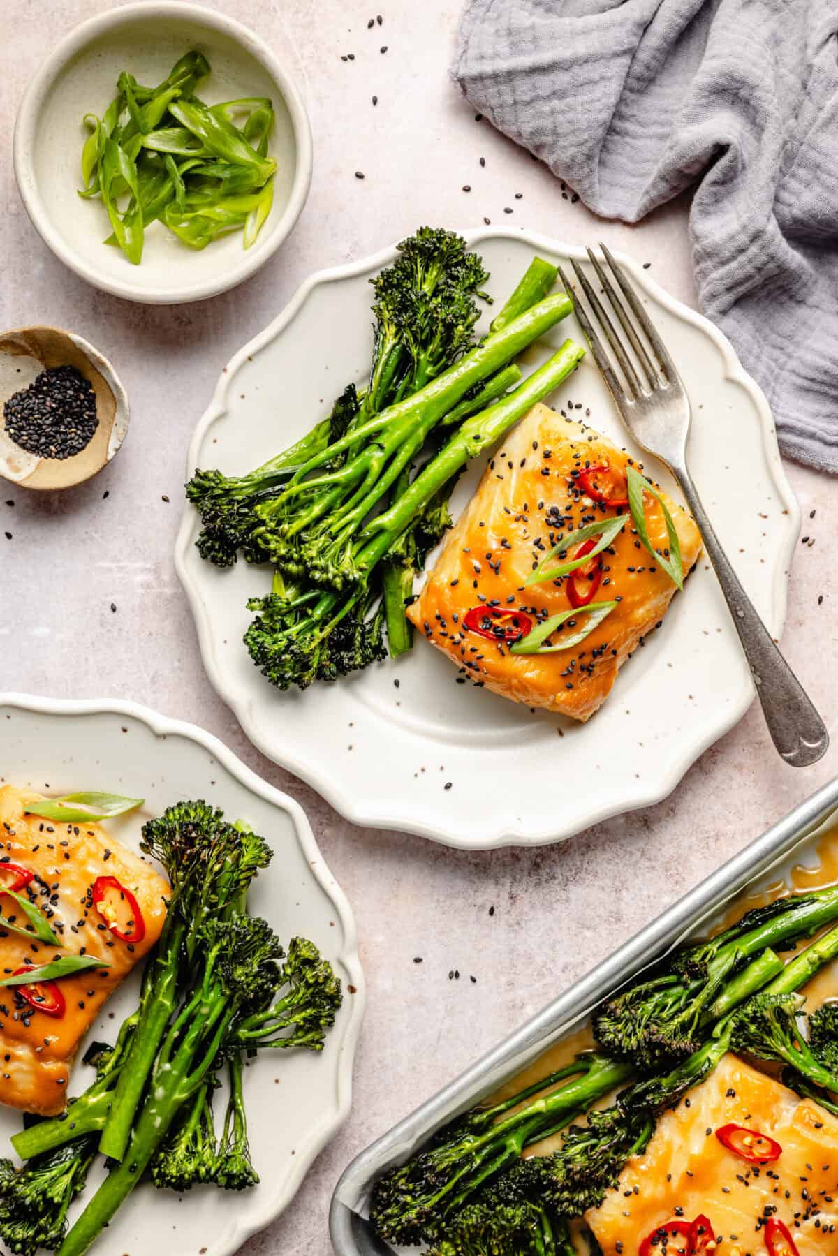 two white ruffled plates with miso-marinated cod with chile peppers and scallions plus broccolini