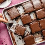 a large sheet pan with portioned slices of frosted chocolate sheet cake