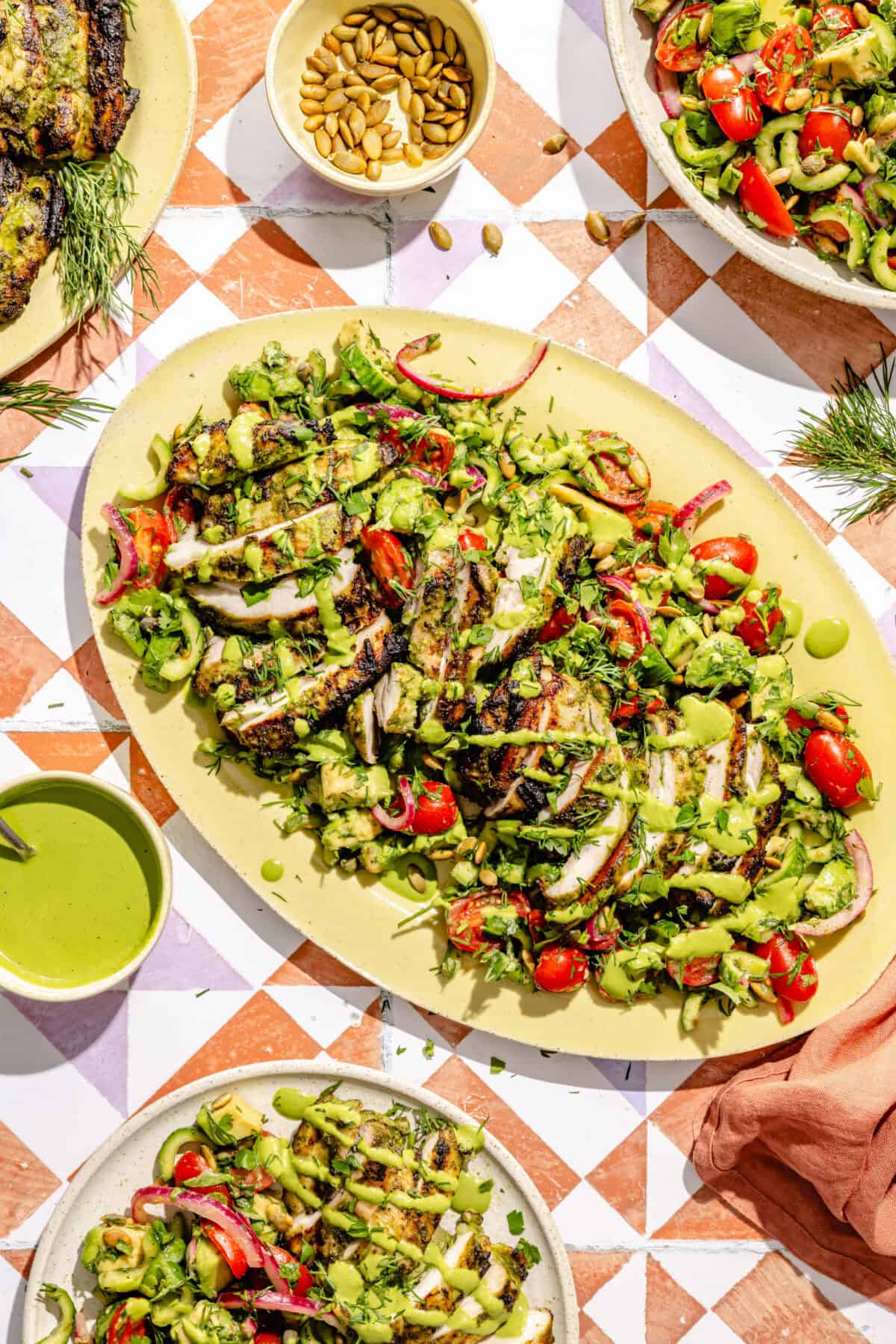 a platter with green goddess marinated grilled chicken thighs and salad