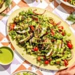 a platter with green goddess marinated grilled chicken thighs and salad