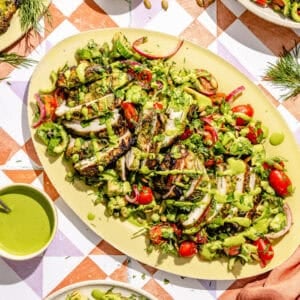 a platter with green goddess marinated grilled chicken thighs and salad