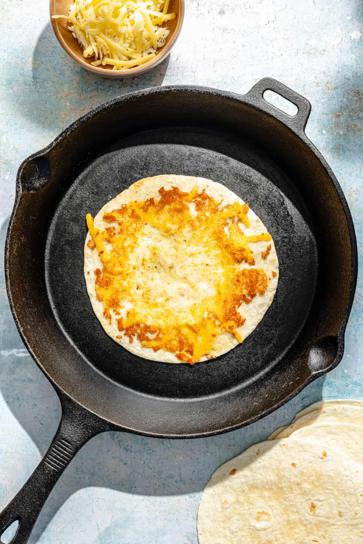 cheese-crusted flour tortillas in a cast-iron skillet