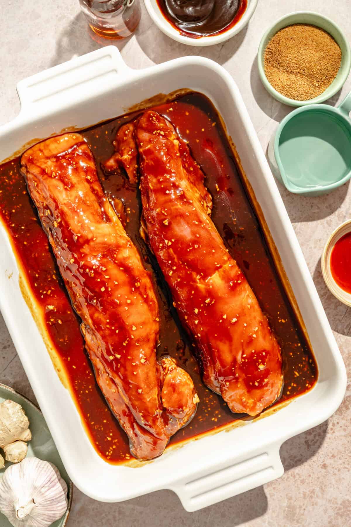 marinated pork tenderloins in a white baking dish