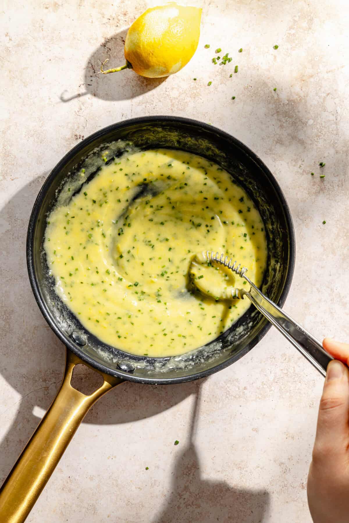 a dark skillet filled with a lemon and chive butter sauce
