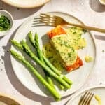 an up-close photo of seared salmon with lemon chive beurre blanc and asparagus stalks