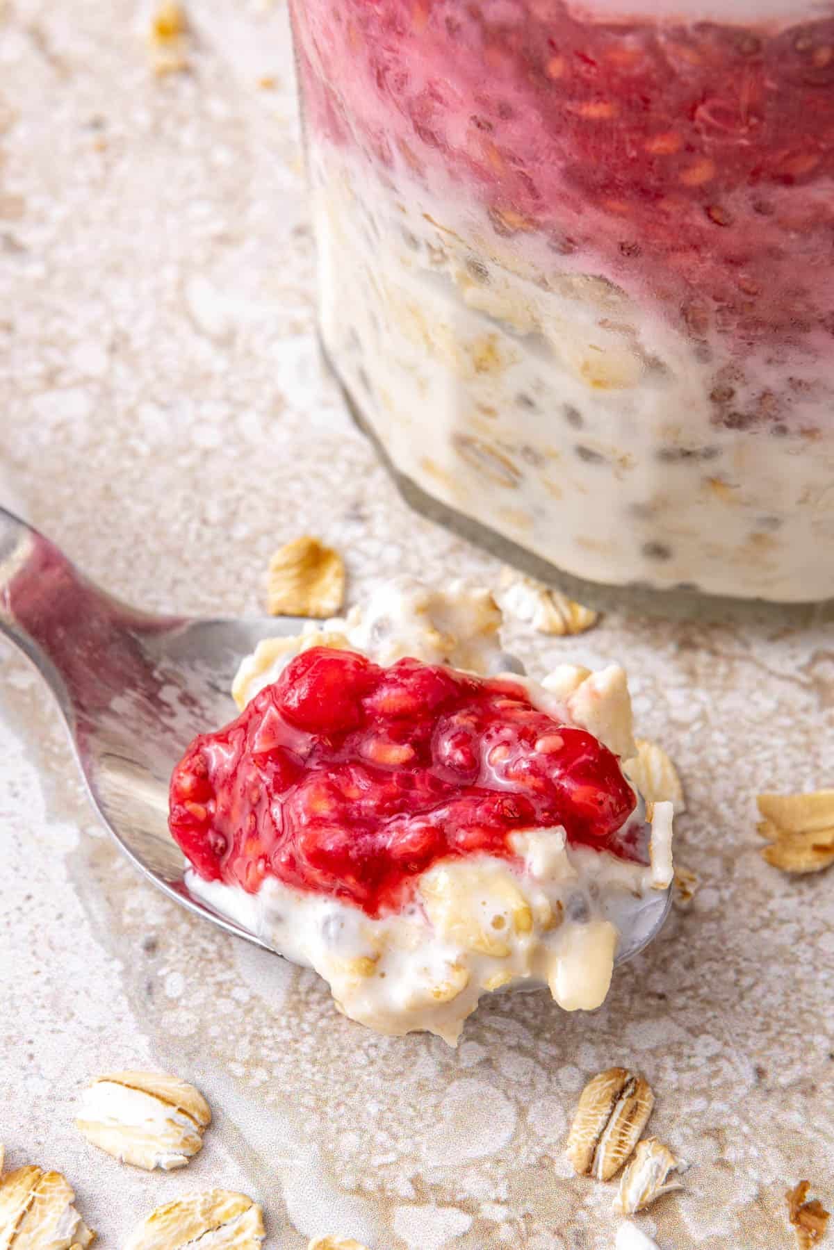 Close up of raspberry chia oats on spoon.