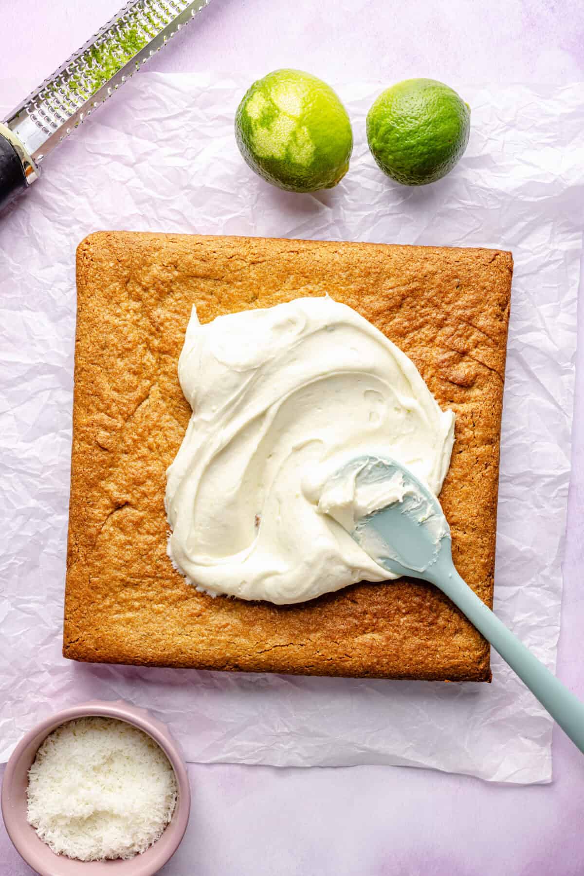 Copycat Starbucks Coconut Lime Bar based getting frosted using a blue spatula.