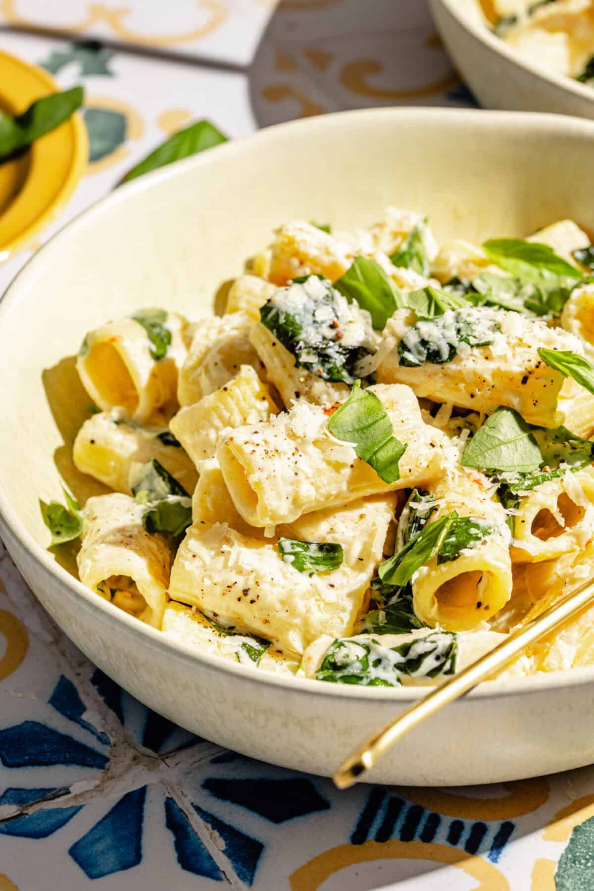 Creamy Lemon Pasta with Ricotta and Basil in shallow bowl on tiled surface.