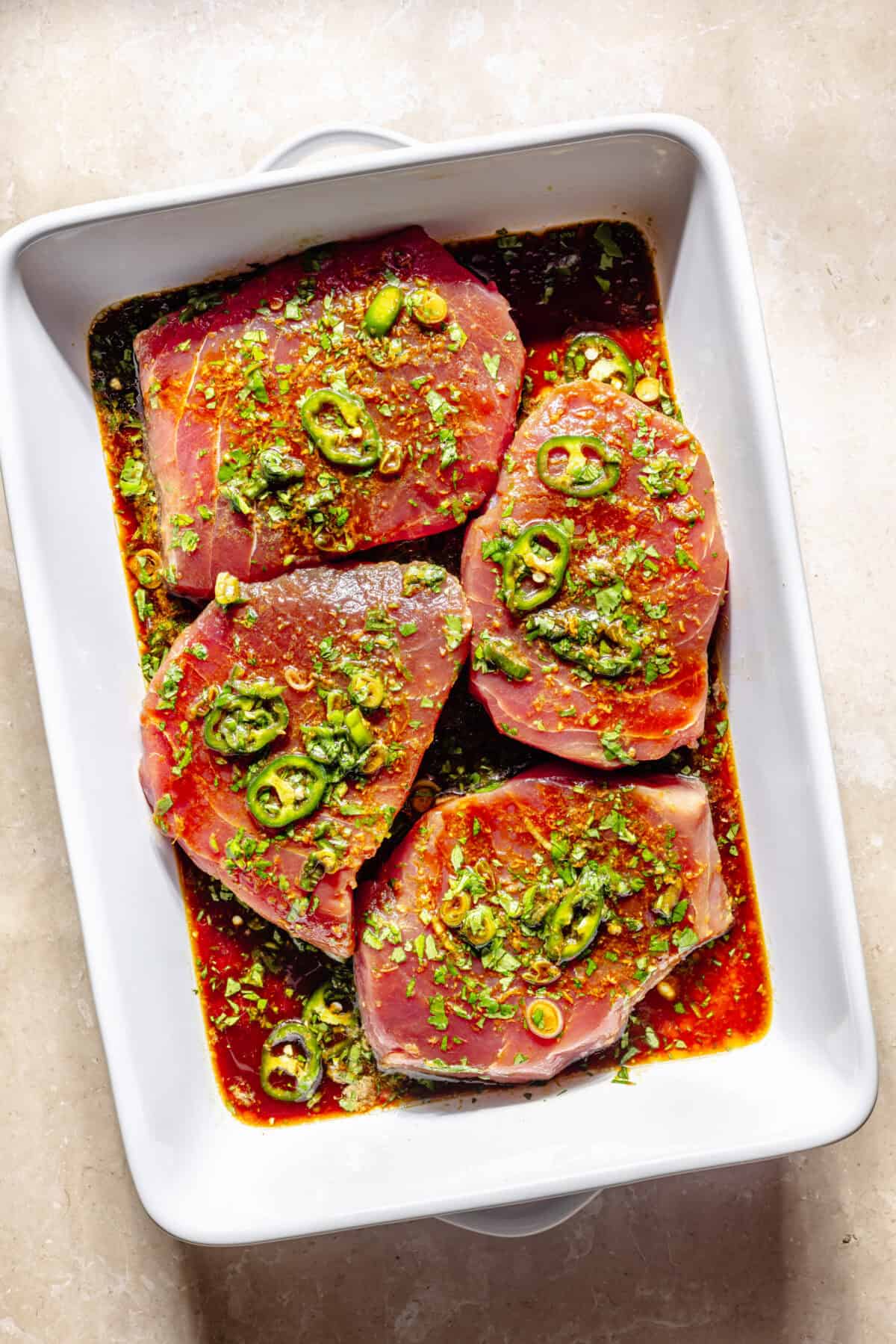 Tuna marinating in baking dish.