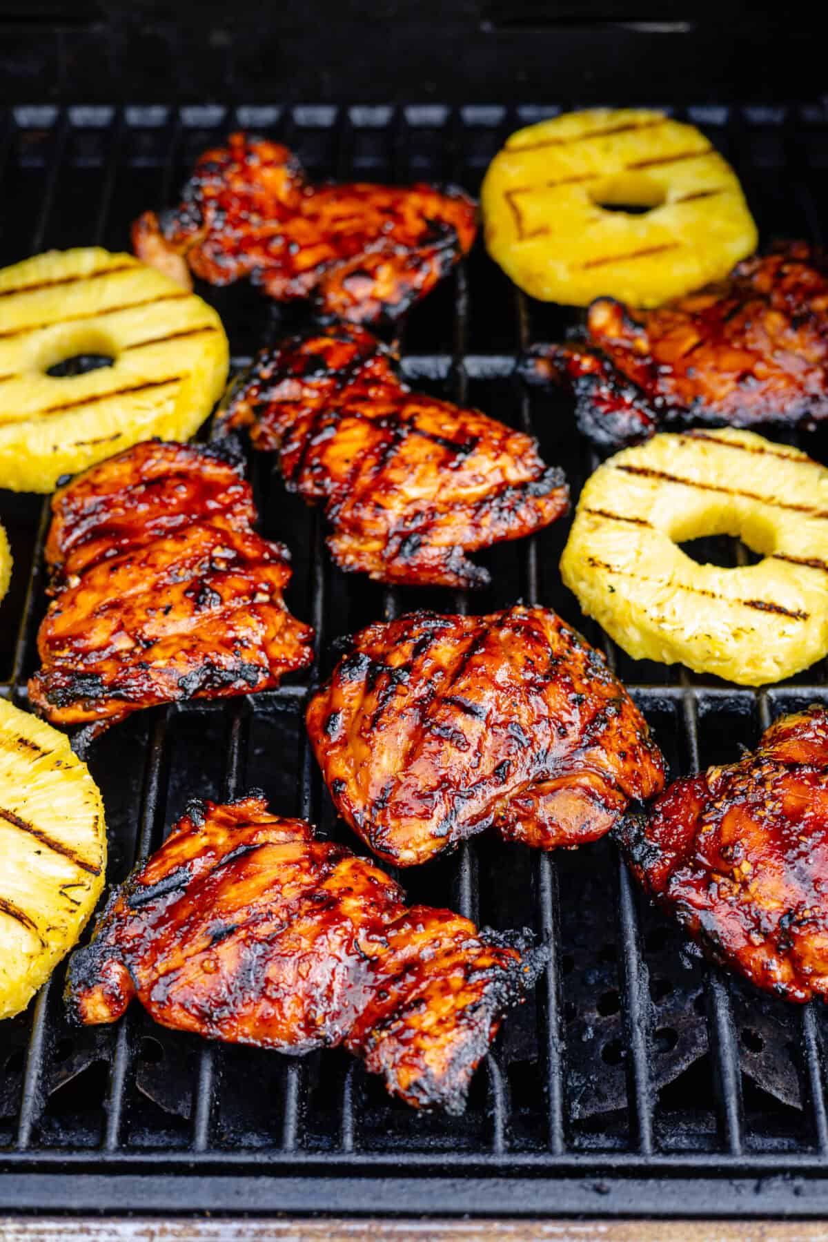 Huli Huli–Inspired Chicken and sliced pineapple on grill cooking.