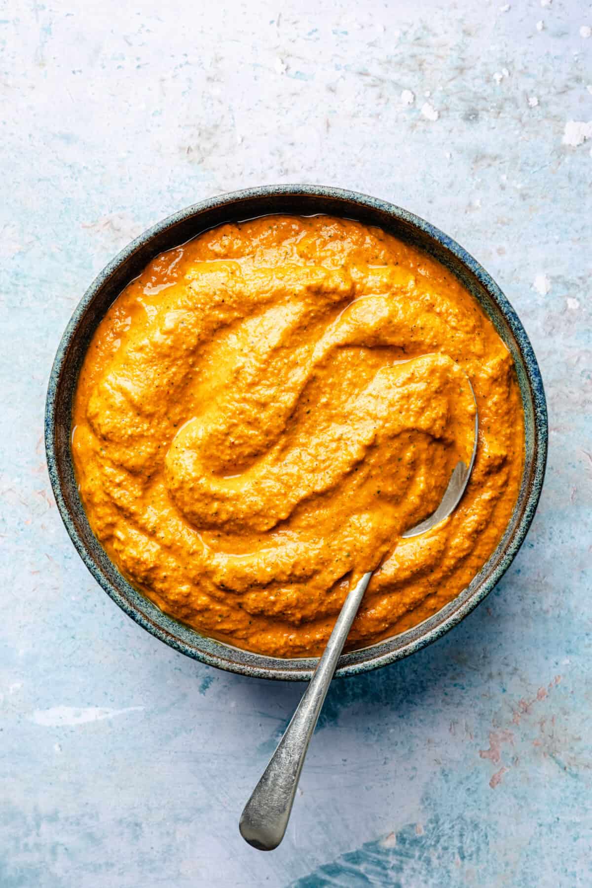 Smoky Romesco sauce in bowl with spoon.