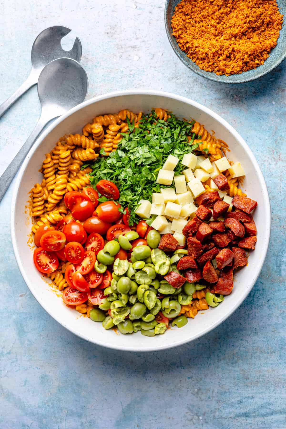 Smoky Romesco Pasta Salad ingredients all in a bowl before being tossed.