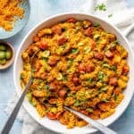 Smoky Romesco Pasta Salad in large bowl on blue backdrop.