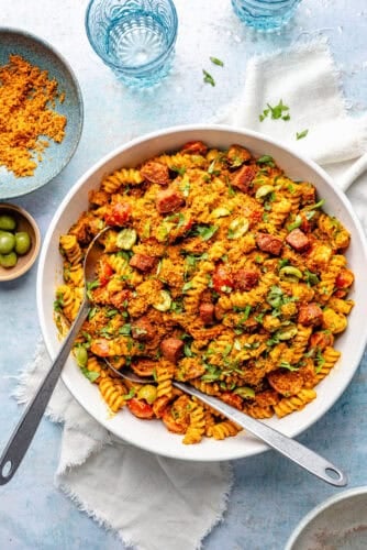Smoky Romesco Pasta Salad in large bowl on blue backdrop.