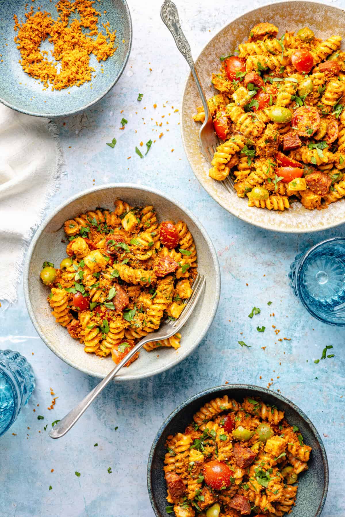 Smoky Romesco Pasta Salad in two bowls on blue background.
