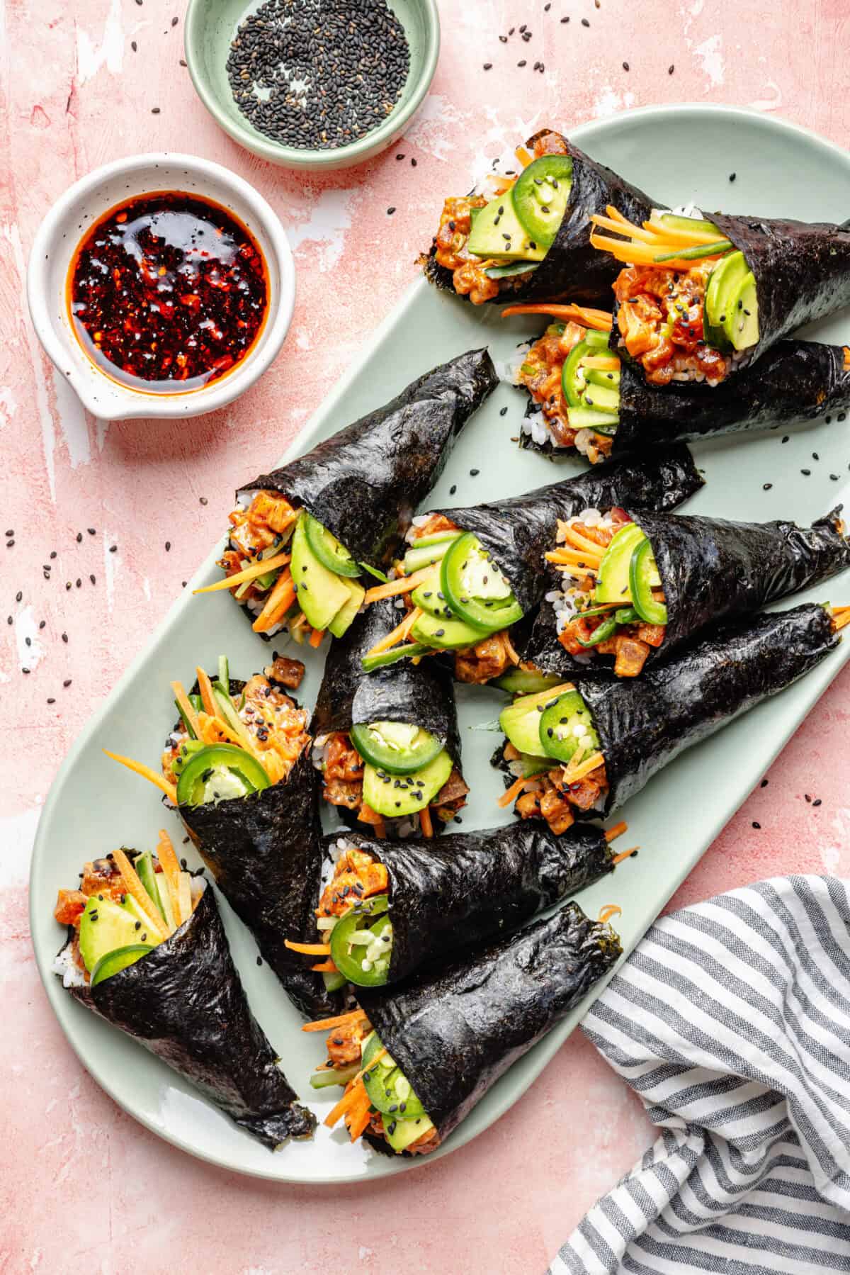 Spicy Tuna Hand Rolls on a platter with small dipping sauce bowl on side.