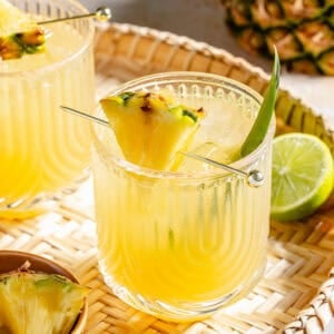 The Flyin' Hawaiian in two glasses on woven tray.