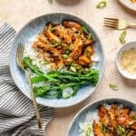 Slow Cooker Honey-Sesame Chicken in two bowls served over rice with side of green beans.
