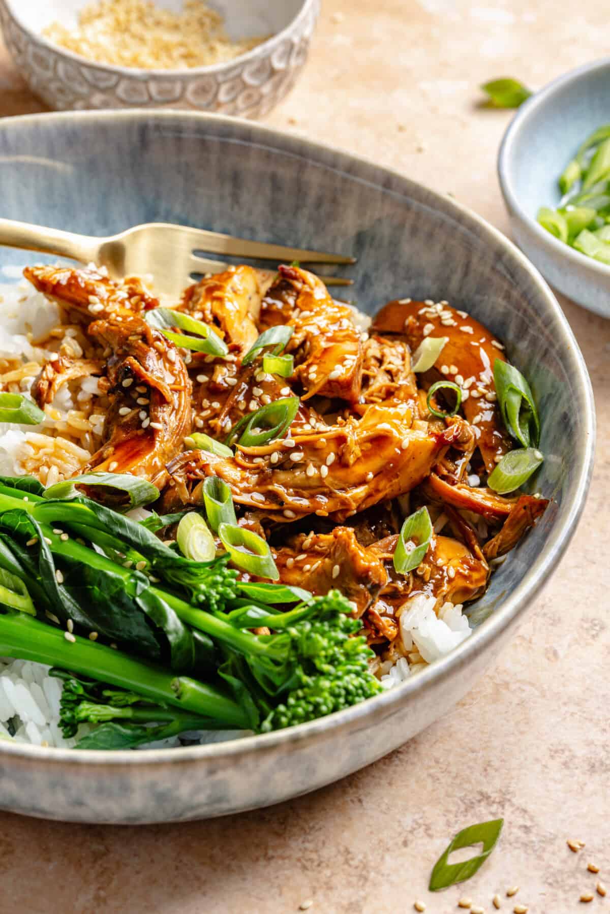 Slow Cooker Honey-Sesame Chicken in bowl served over rice with green beans.