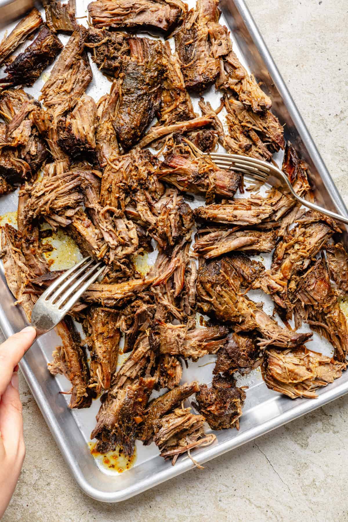 Slow Cooker Miso-Ginger Chuck Roast shredded on sheet pan.