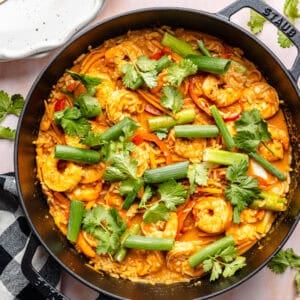 20-Minute Thai-Inspired Coconut Shrimp Curry in skillet with plates around it.
