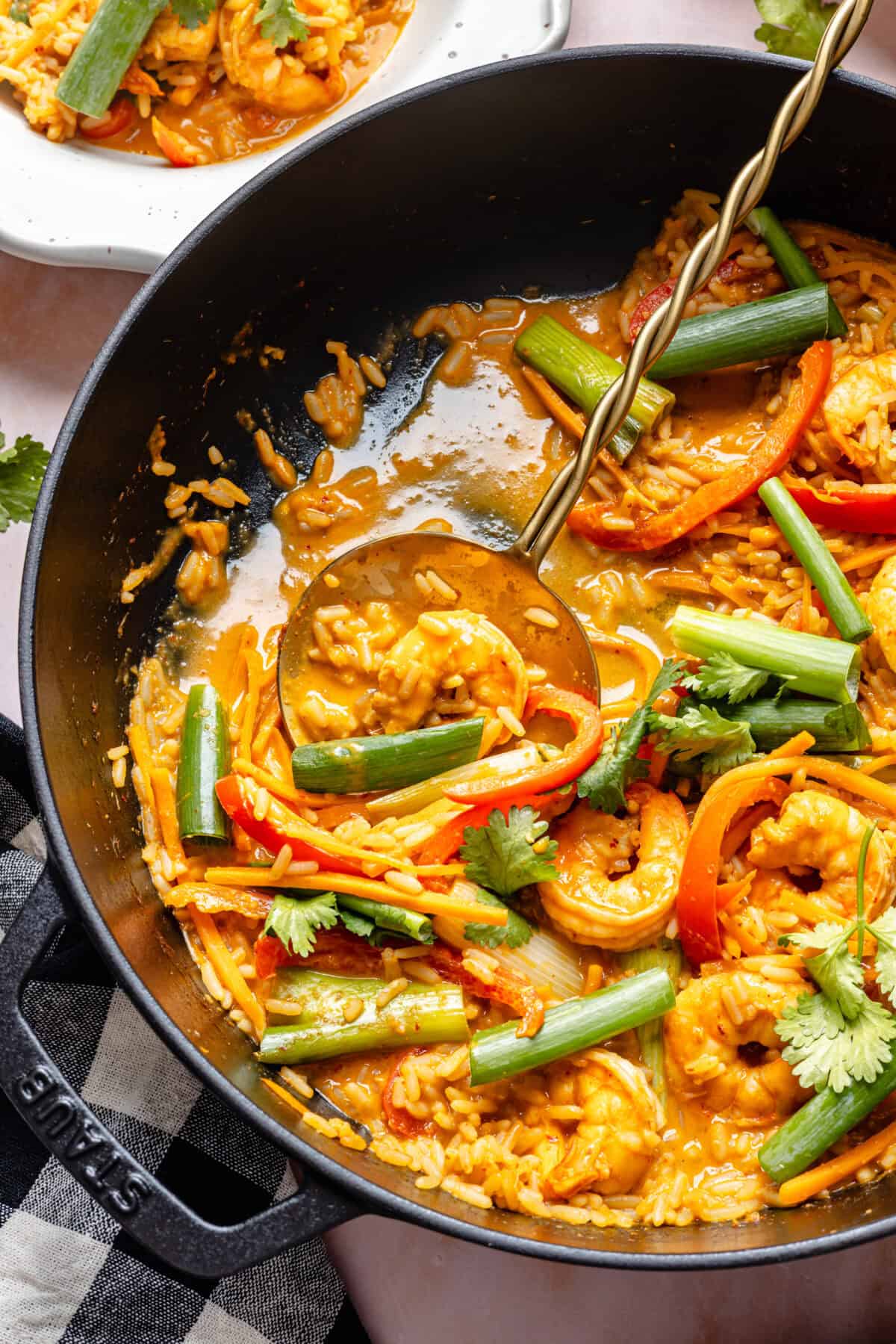 20-Minute Thai-Inspired Coconut Shrimp Curry getting ladeled into bowls.