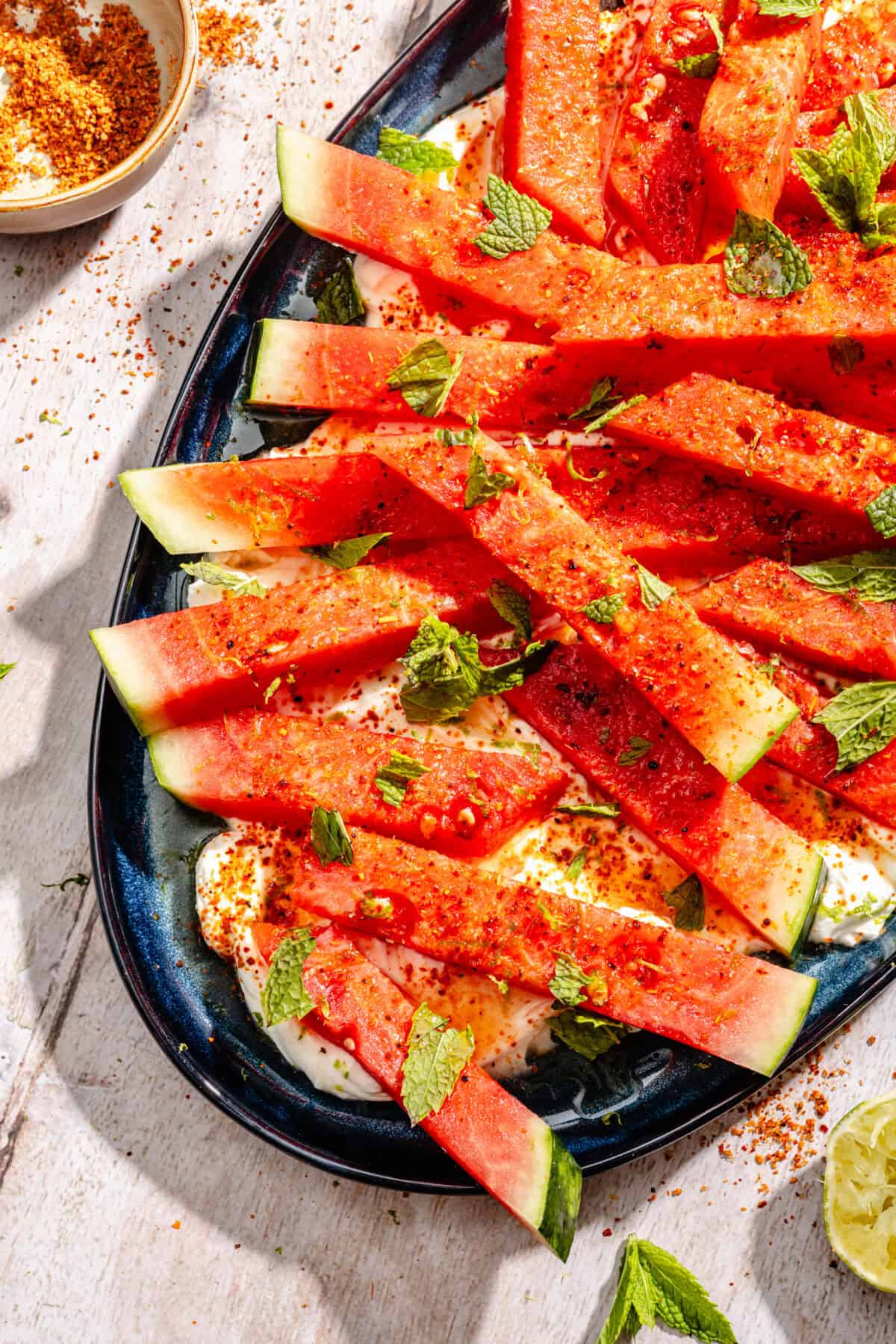 Chili Lime Watermelon with Labneh and Hot Honey on blue platter.