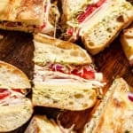 Turkey and Havarti Party Sandwiches with Dill-Pickle Mayo sliced on wooden cutting board.